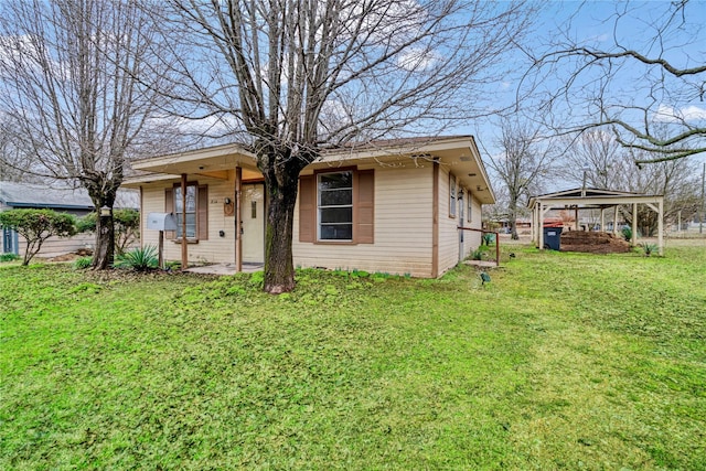 view of front of property with a front yard and a carport