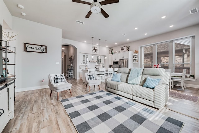 1845 Leo Dr, Van Alstyne, TX 75495 - living room featuring ceiling fan, arched walkways, light wood-type flooring, baseboards, and recessed lighting