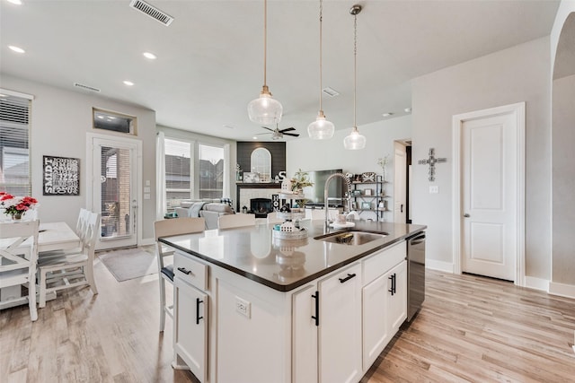 1845 Leo Dr, Van Alstyne, TX 75495 - kitchen featuring a sink, dark countertops, stainless steel dishwasher, a ceiling fan, and light wood finished floors