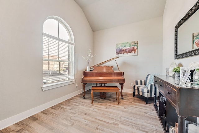 sitting room with vaulted ceiling, baseboards, and light wood-style floors