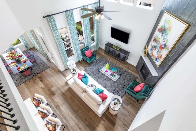 living room featuring hardwood / wood-style flooring, ceiling fan, and a high ceiling