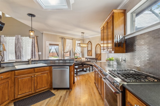 kitchen with appliances with stainless steel finishes, brown cabinetry, and a sink