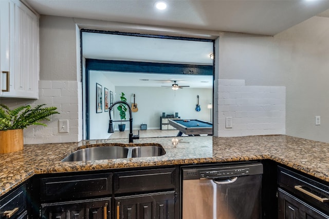 kitchen with sink, white cabinetry, stainless steel dishwasher, dark stone counters, and decorative backsplash