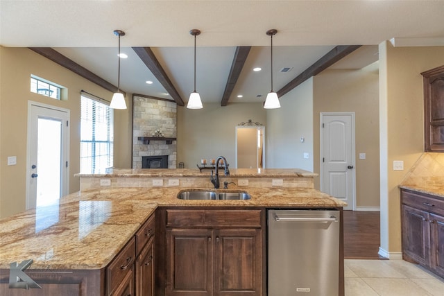 kitchen featuring sink, hanging light fixtures, beam ceiling, a center island with sink, and stainless steel dishwasher