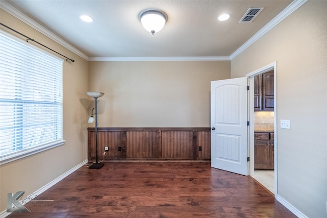 spare room with crown molding and dark wood-type flooring