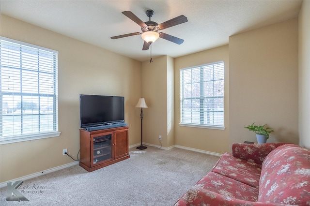 living room featuring light carpet, plenty of natural light, and ceiling fan