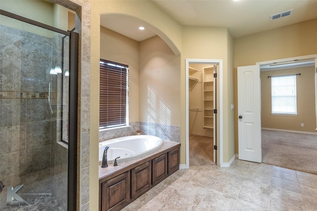 158 Stardust Trl, Tuscola, TX 79562 - bathroom featuring a shower stall, a walk in closet, a bath, tile patterned floors, and baseboards