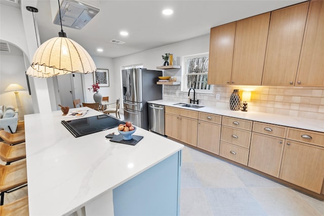 kitchen featuring stainless steel appliances, tasteful backsplash, a kitchen island, and sink