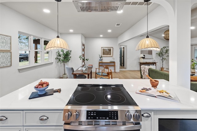 kitchen featuring pendant lighting, electric range, and light hardwood / wood-style flooring