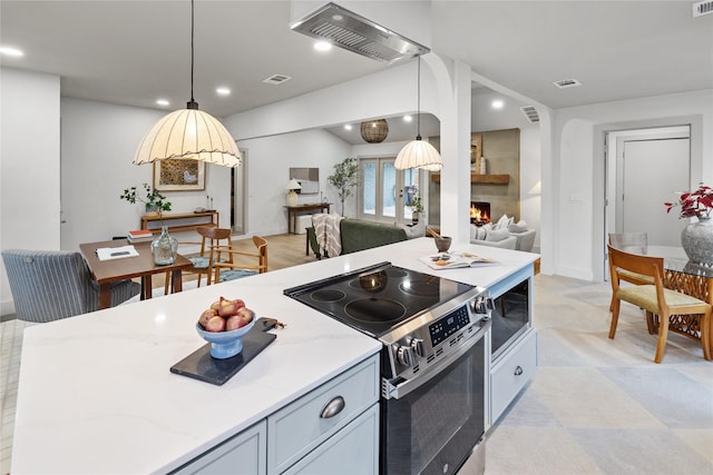 kitchen featuring pendant lighting, appliances with stainless steel finishes, and light stone countertops