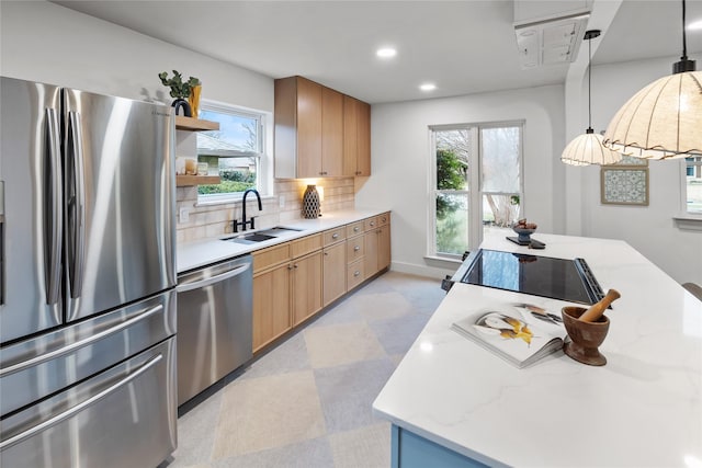 kitchen featuring decorative light fixtures, sink, backsplash, stainless steel appliances, and light stone countertops