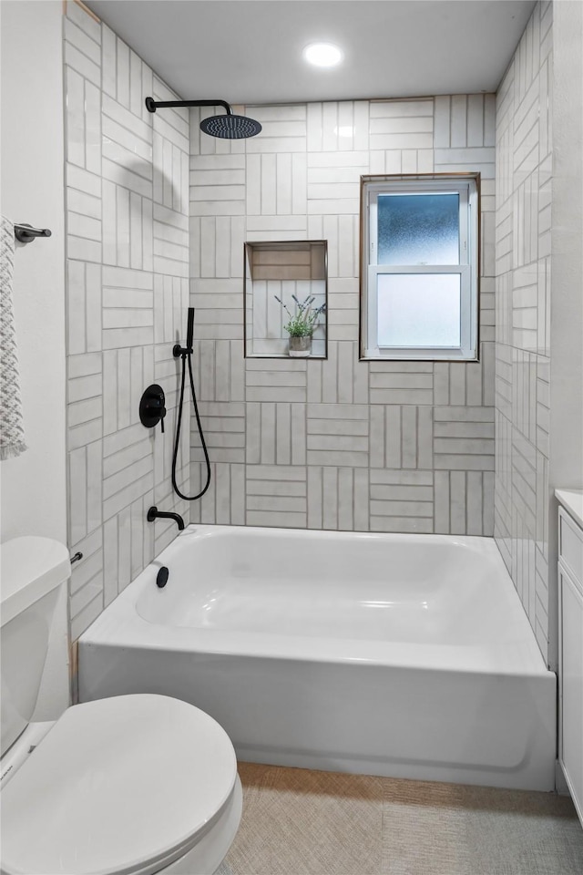 bathroom featuring tiled shower / bath combo and toilet