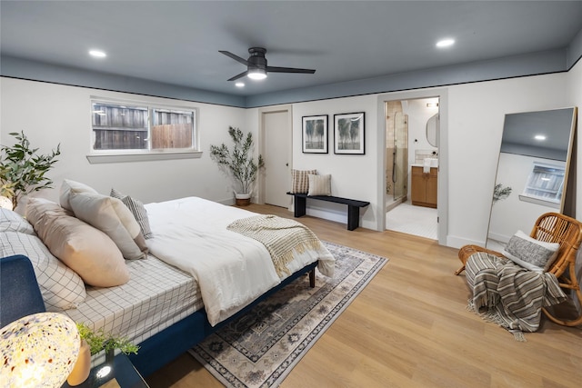 bedroom with connected bathroom and light hardwood / wood-style flooring