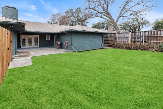 rear view of property with a patio area, french doors, and a lawn