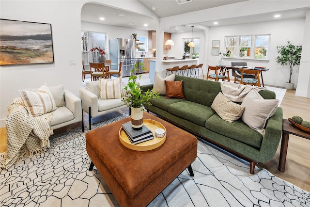 living room featuring lofted ceiling and light wood-type flooring