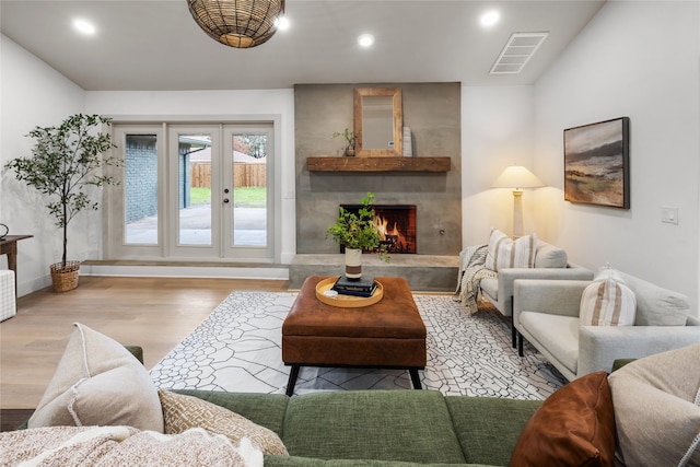 living room with a large fireplace and light wood-type flooring