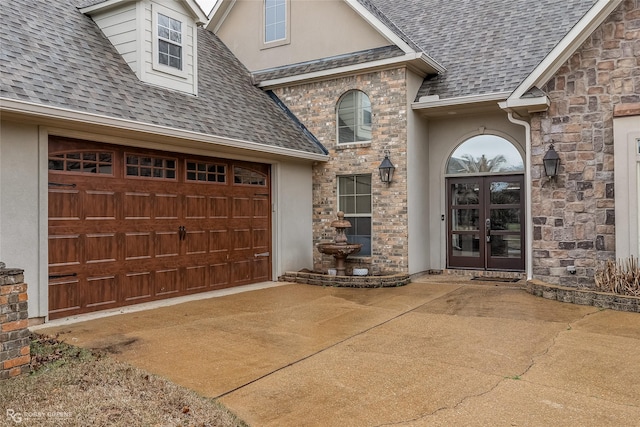 view of exterior entry with french doors and a garage