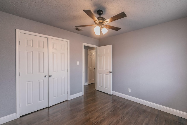 unfurnished bedroom featuring ceiling fan, dark hardwood / wood-style floors, a closet, and a textured ceiling