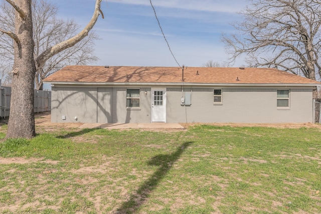 rear view of property featuring a patio area and a lawn