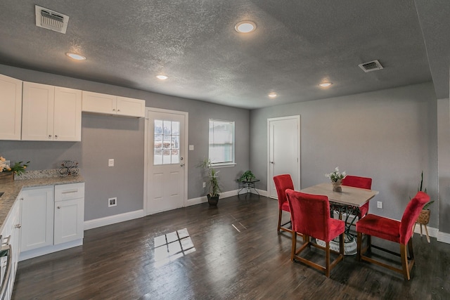 dining area featuring a textured ceiling and dark hardwood / wood-style flooring