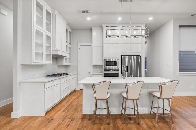 625 N Tyler St Unit 402, Dallas, TX 75208 - kitchen featuring visible vents, a kitchen bar, light countertops, backsplash, and stainless steel appliances