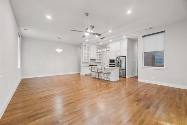 625 N Tyler St Unit 402, Dallas, TX 75208 - unfurnished living room featuring visible vents, recessed lighting, baseboards, and ceiling fan with notable chandelier