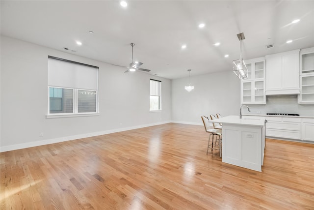 625 N Tyler St Unit 402, Dallas, TX 75208 - kitchen featuring a breakfast bar area, light countertops, cooktop, ceiling fan with notable chandelier, and open floor plan