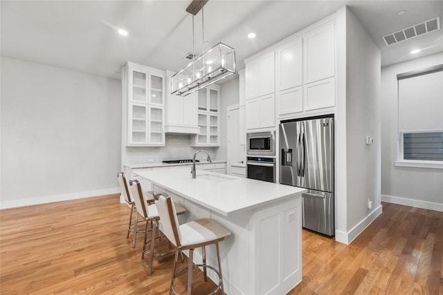 625 N Tyler St Unit 402, Dallas, TX 75208 - kitchen with visible vents, baseboards, white cabinets, a sink, and stainless steel appliances