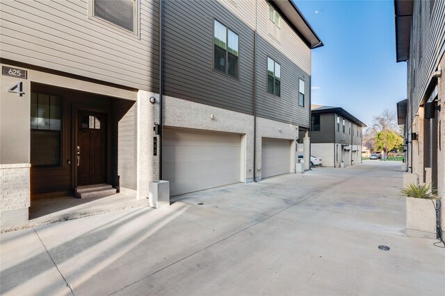 625 N Tyler St Unit 402, Dallas, TX 75208 - view of side of home featuring driveway, a residential view, and a garage