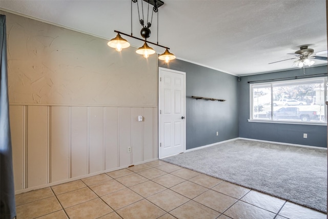 spare room with ceiling fan, light colored carpet, crown molding, and a textured ceiling