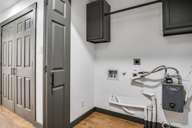 clothes washing area with gas dryer hookup, cabinets, light wood-type flooring, hookup for a washing machine, and electric dryer hookup