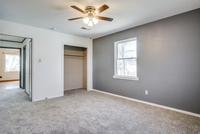 unfurnished bedroom with ceiling fan, a closet, and light carpet