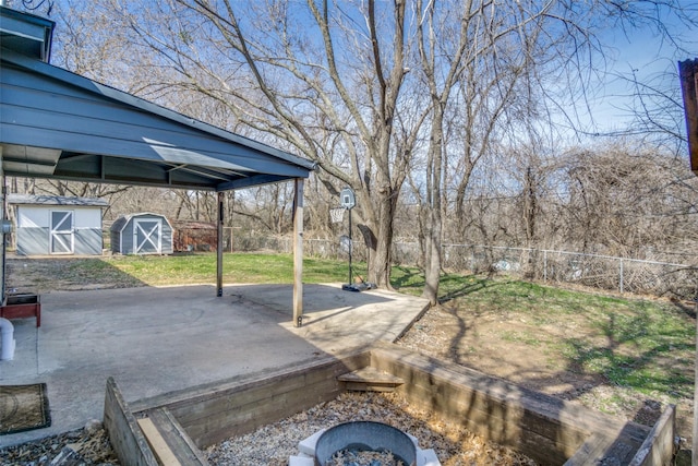 view of yard with a storage shed, a fire pit, and a patio area