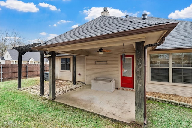 rear view of house with ceiling fan, a patio area, and a lawn