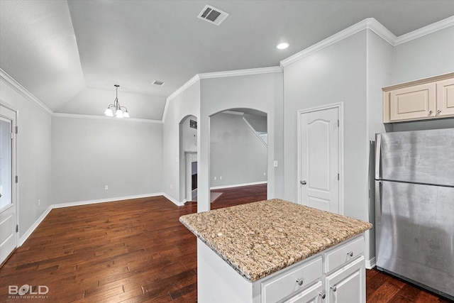 kitchen with light stone counters, a center island, stainless steel refrigerator, ornamental molding, and dark hardwood / wood-style flooring