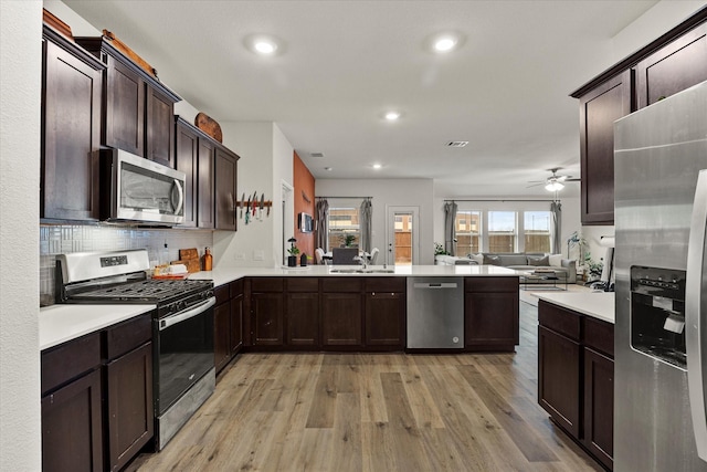 126 Condor Pass, Caddo Mills, TX 75135 - kitchen featuring appliances with stainless steel finishes, open floor plan, a peninsula, light countertops, and recessed lighting