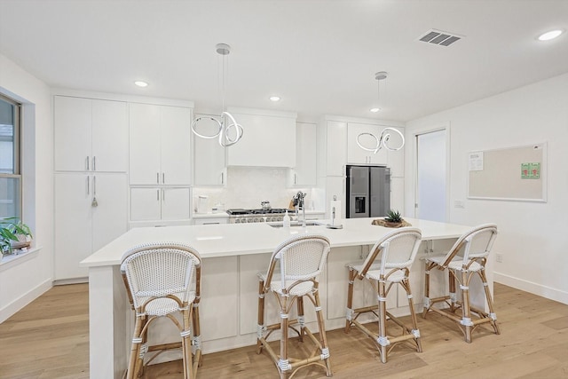 5809 Fursman Ave, Fort Worth, TX 76114 - kitchen featuring stainless steel fridge, light countertops, light wood-style flooring, a spacious island, and recessed lighting