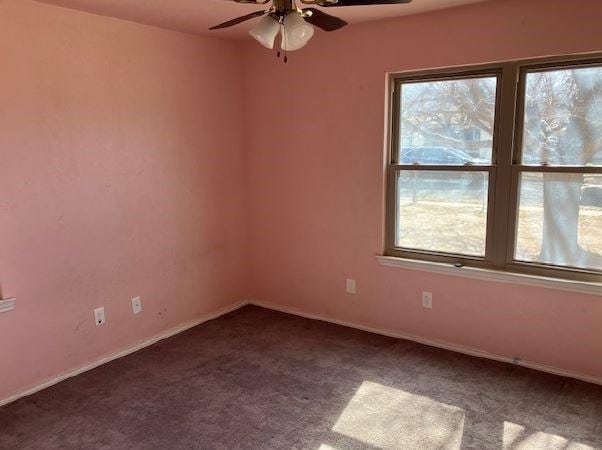 carpeted empty room with a wealth of natural light and ceiling fan