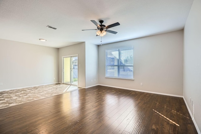 unfurnished room featuring dark wood-type flooring, ceiling fan, and a textured ceiling