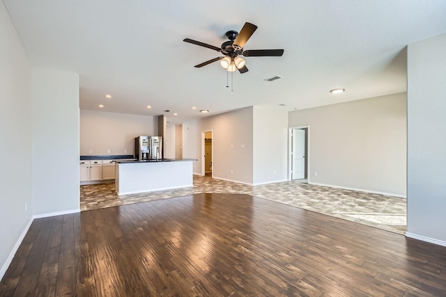 unfurnished living room with ceiling fan and dark hardwood / wood-style floors