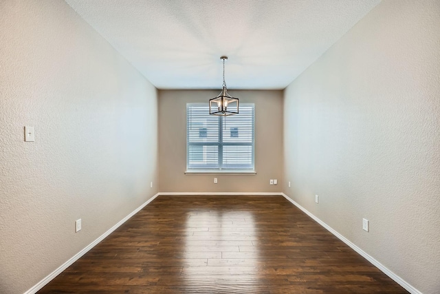 unfurnished dining area with dark wood-type flooring and a textured ceiling