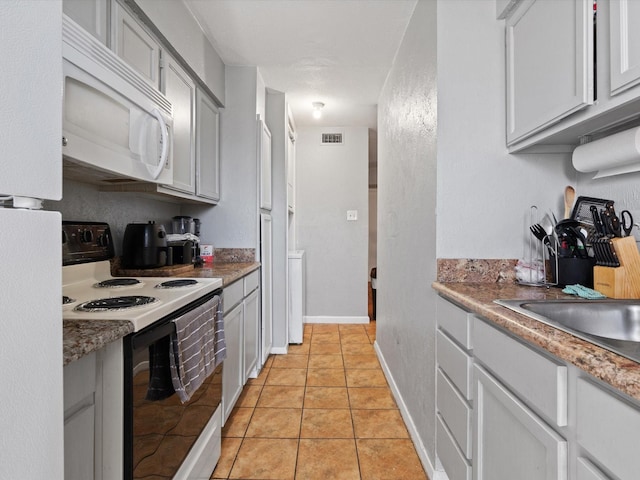 kitchen featuring electric range and light tile patterned flooring