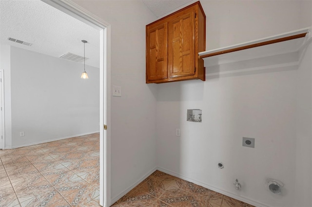 laundry area featuring cabinets, washer hookup, a textured ceiling, hookup for a gas dryer, and hookup for an electric dryer