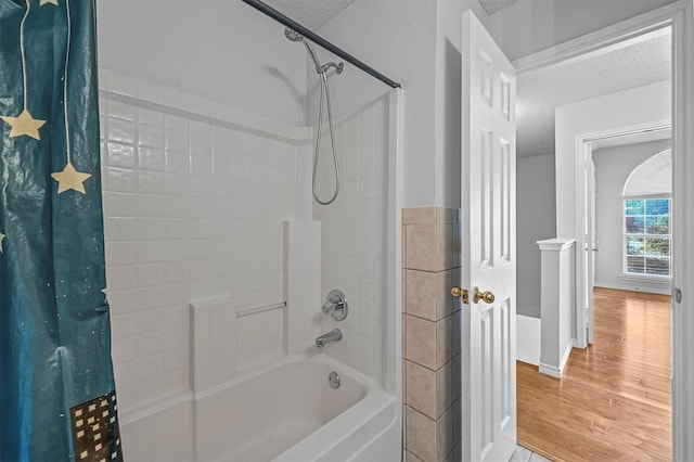 bathroom with shower / bath combo, hardwood / wood-style floors, and a textured ceiling