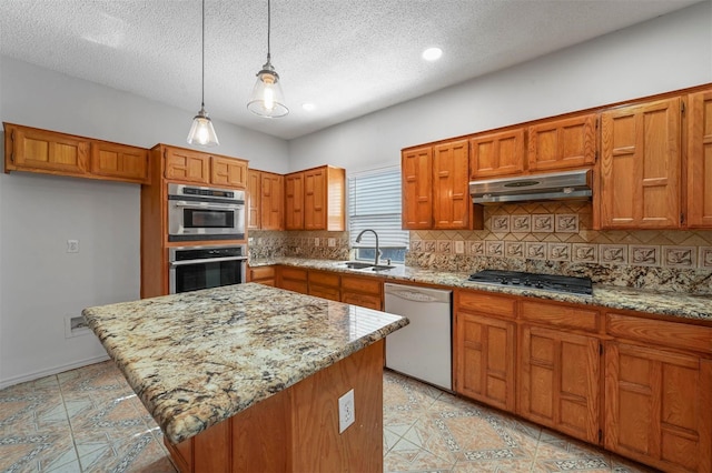 kitchen with appliances with stainless steel finishes, sink, decorative backsplash, hanging light fixtures, and light stone countertops