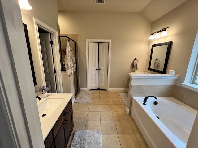 bathroom with tile patterned floors, visible vents, vanity, baseboards, and a bath