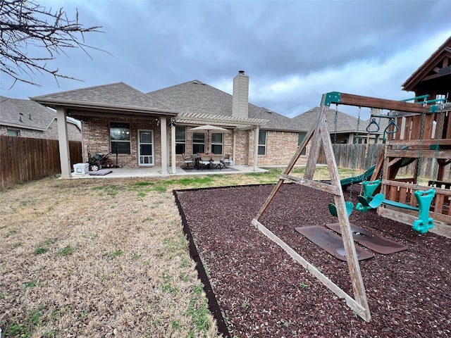 rear view of property with a playground, a patio, a fenced backyard, and brick siding