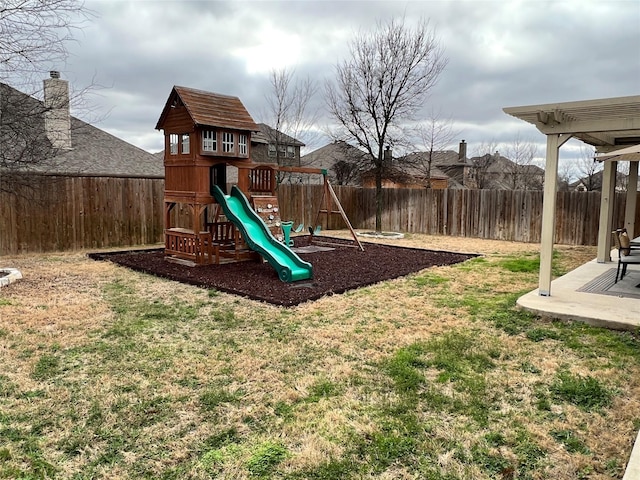 view of playground with a fenced backyard, a lawn, and a patio