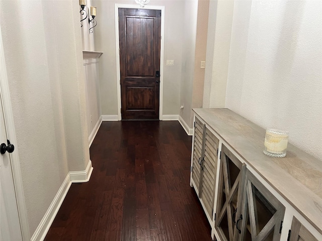 entryway with dark wood finished floors and baseboards