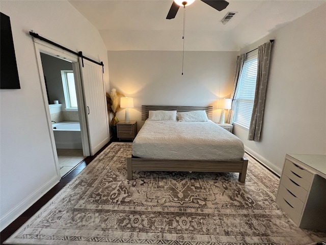 bedroom with visible vents, a barn door, ceiling fan, vaulted ceiling, and baseboards